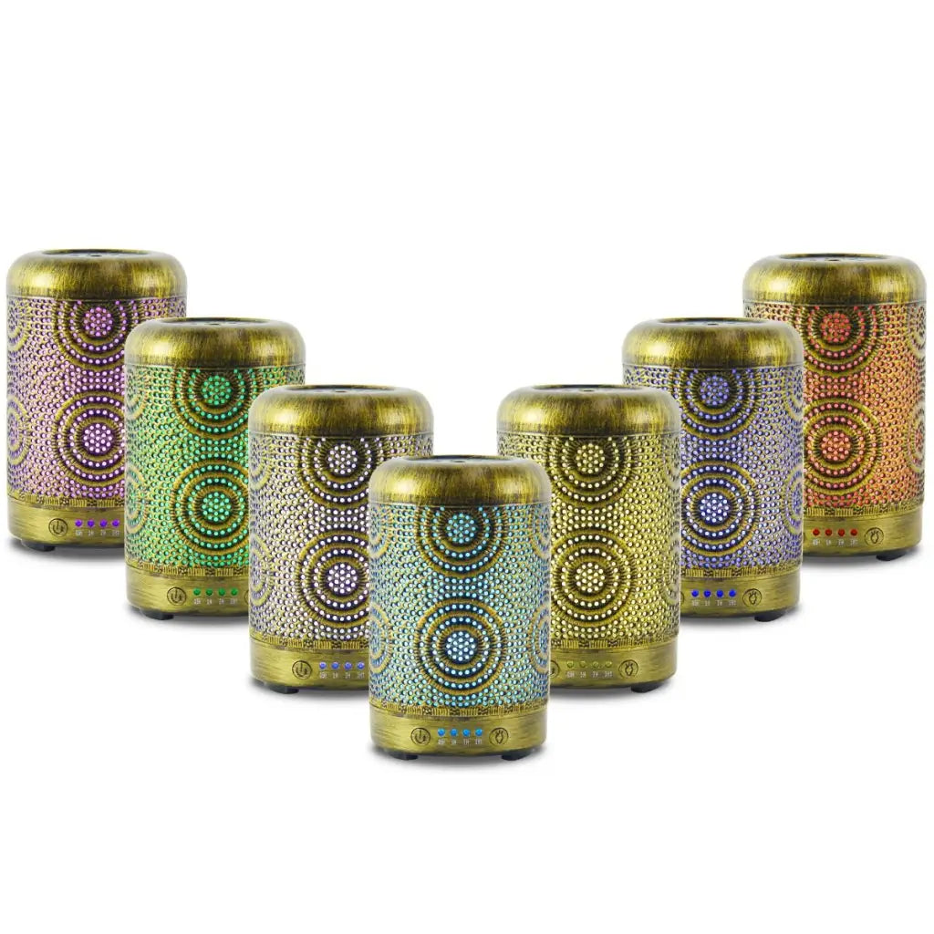 7 different led light colours of the activiva metal vintage gold diffusers 100ml standing in v shape on white background.