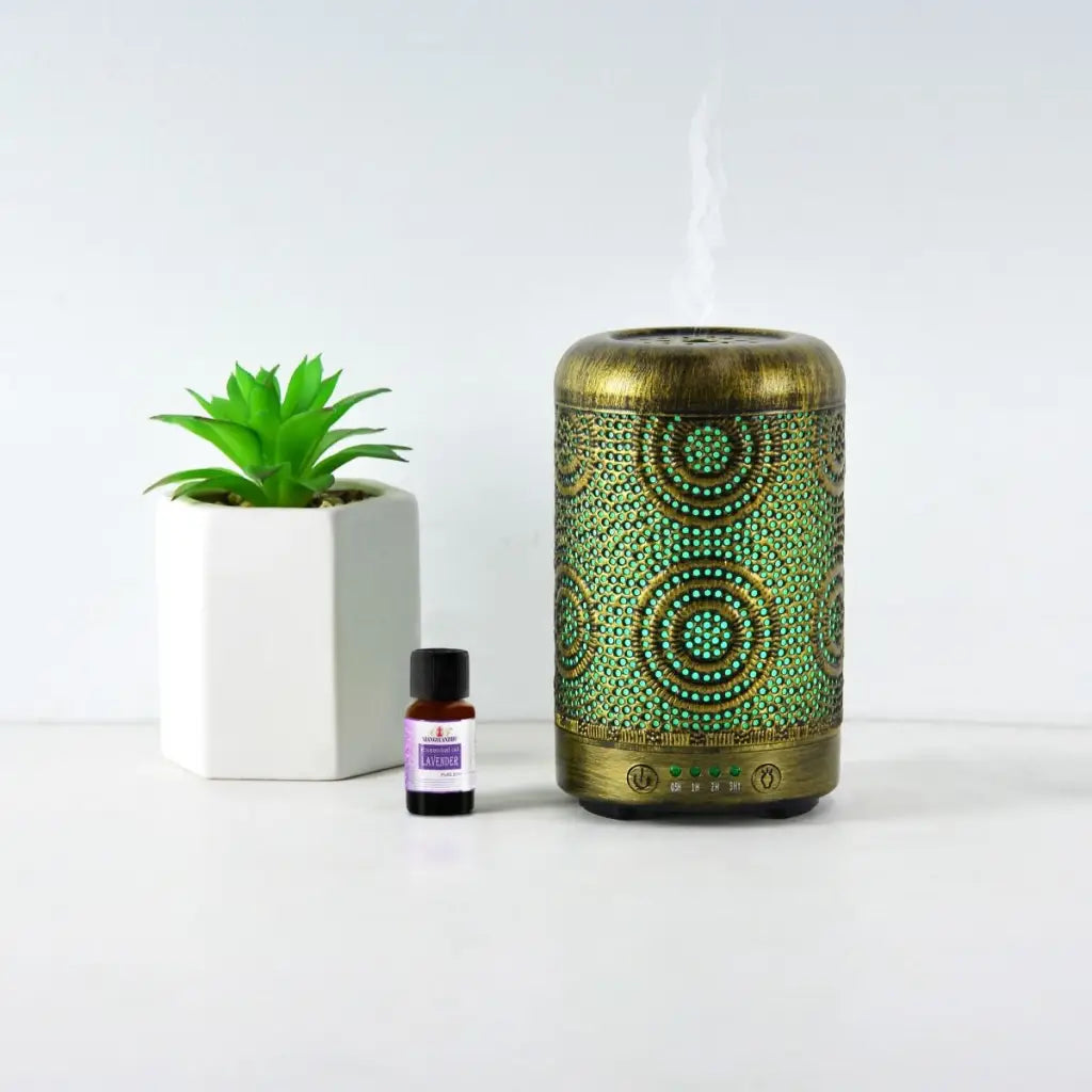Activiva Metal Diffuser 100ml Vintage Gold with small green plant and oil bottle on white background.