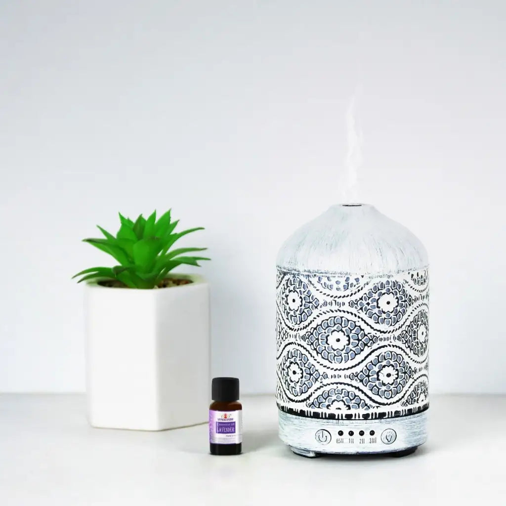 Activiva Metal Diffuser 100ml Vintage White with small green plant and oil bottle on white background.