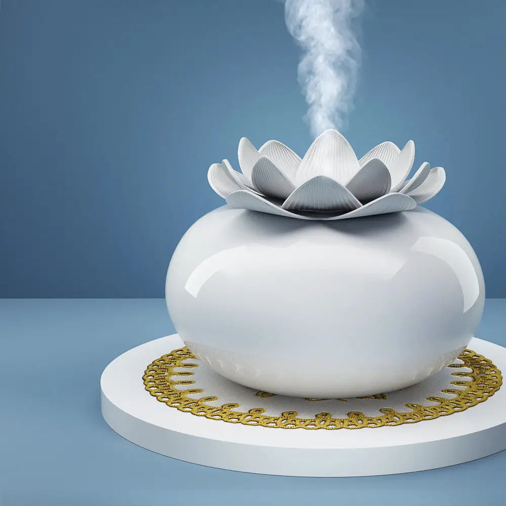 round white ceramic lotus diffuser sitting on round white tray with blue background.