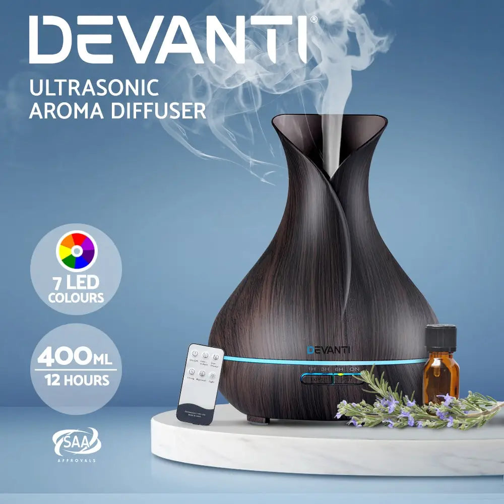 dark wood devanti 4 in 1 diffuser with remote control and steam sitting on white marble with blue background.