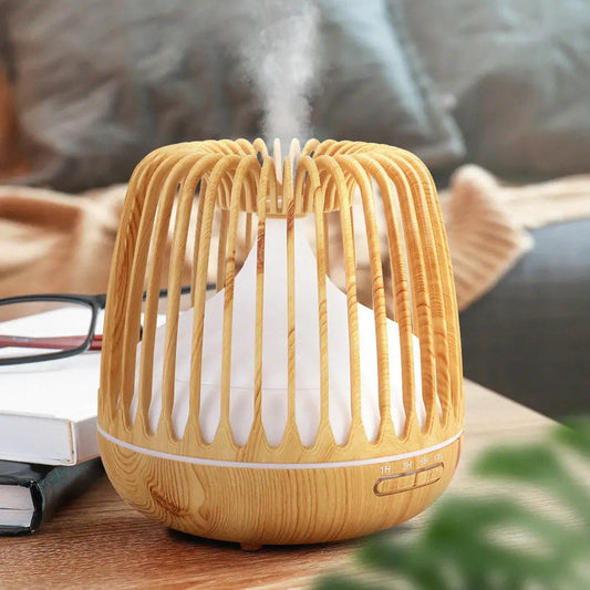 Devanti 4-In-1 Ultrasonic Aroma Diffuser in Light Wood Grain Sitting on Timber Table With Steam Coming Out of Top.