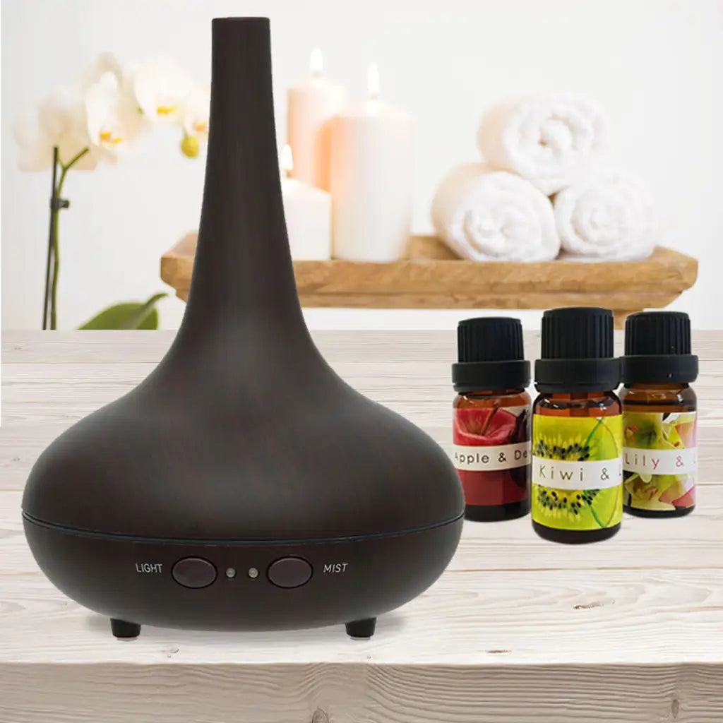 Essential dark wood genie shape Diffuser with 3 oil bottles sitting on light timber table.